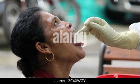 Mumbai, Inde. 29 juin 2020. Une femme ouvre la bouche pour un échantillon d'écouvillonnage pendant le test Covid-19.le gouvernement de Maharashtra a prolongé le verrouillage du coronavirus (COVID-19) jusqu'en juillet 31, dans le contexte d'une croissance régulière du nombre d'infectés par le COVID-19 dans l'État. Les mouvements pour les activités non essentielles seront limités dans les quartiers. Crédit : SOPA Images Limited/Alamy Live News Banque D'Images