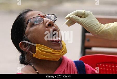 Mumbai, Inde. 29 juin 2020. Une femme ouvre la bouche pour un échantillon d'écouvillonnage pendant le test Covid-19.le gouvernement de Maharashtra a prolongé le verrouillage du coronavirus (COVID-19) jusqu'en juillet 31, dans le contexte d'une croissance régulière du nombre d'infectés par le COVID-19 dans l'État. Les mouvements pour les activités non essentielles seront limités dans les quartiers. Crédit : SOPA Images Limited/Alamy Live News Banque D'Images