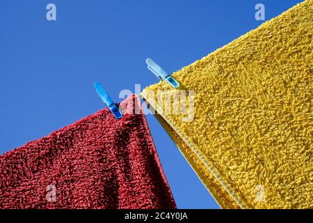 serviettes rouges et jaunes séchant sur la ligne de vêtements de jardin, norfolk, angleterre Banque D'Images