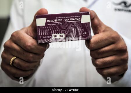 Giza, Égypte. 29 juin 2020. Un employé de la société pharmaceutique égyptienne Eva Pharma détient un emballage contenant des flacons de Remdesivir, un médicament antiviral à large spectre approuvé comme traitement spécifique pour COVID-19, à l'usine de la société, qui a commencé à produire le médicament cette semaine avec une capacité de production pouvant atteindre 1.5 millions de doses par mois. Crédit : Fadel Dawood/dpa/Alay Live News Banque D'Images