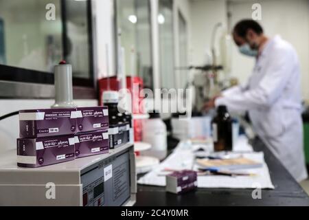 Giza, Égypte. 29 juin 2020. Les boîtes contenant des flacons de Remdesivir, un médicament antiviral à large spectre approuvé comme traitement spécifique pour COVID-19, se trouvent à côté d'un employé de la société pharmaceutique égyptienne Eva Pharma à l'usine de la société, qui a commencé à produire le médicament cette semaine avec une capacité de production pouvant atteindre 1.5 millions de doses par mois. Crédit : Fadel Dawood/dpa/Alay Live News Banque D'Images