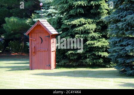 un bâtiment de toilettes privé, un espace de grand standing rural rouge, dans une forêt ensoleillée Banque D'Images