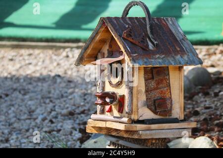 un unique rustique maison d'oiseaux en étain sur toit sur un sol en pierre Banque D'Images