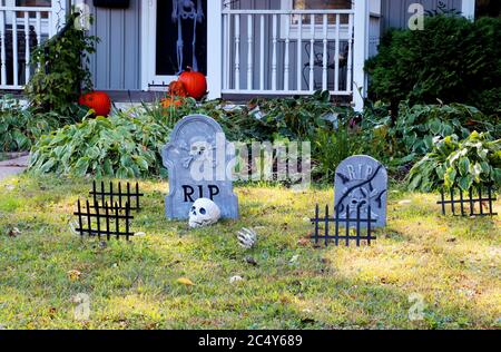 Cour avant de maison privée décorée de faux crâne, des os mains, des pierres tombales et des grilles, des citrouilles sur le porche pour un vieux trick-or-Treat Hlo américain Banque D'Images