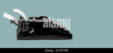 Ancienne machine à écrire noire avec feuille de papier blanche. Masque inclus. Vue latérale Banque D'Images