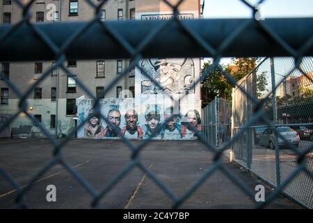 Des œuvres d'art ornent le côté d'un bâtiment dans un parking clos Banque D'Images