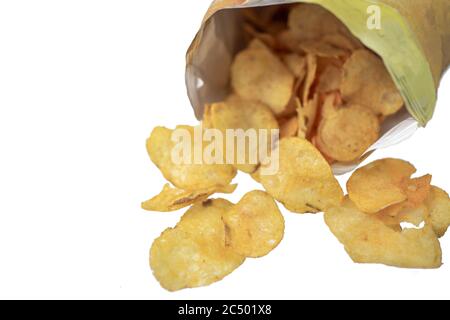 Les chips de pomme de terre versées à partir d'un sac reposent sur un fond blanc. Macro Banque D'Images