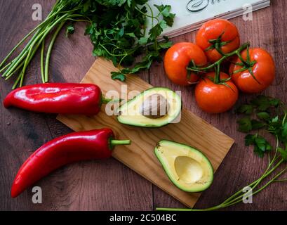 Une sélection de magnifiques légumes frais sur un plan de travail avec planche à découper. Banque D'Images