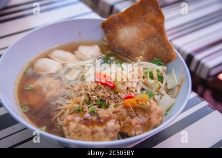 'Kway Tiew Gai', soupe traditionnelle thaïlandaise aux nouilles de riz, boulettes de poulet, boulettes de poisson, ail croustillant, pousses, arachides et Wonton croustillant Banque D'Images