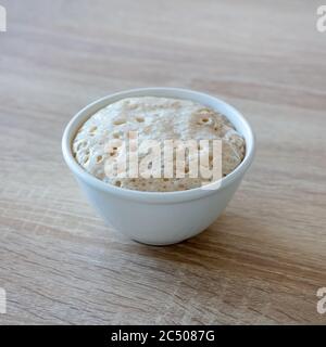 levure dans un bol sur une table de cuisine en bois Banque D'Images