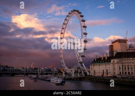 Le London Eye en fin d'après-midi, lumière avec ciel nuageux et vue sur la Tamise et le County Hall. Banque D'Images