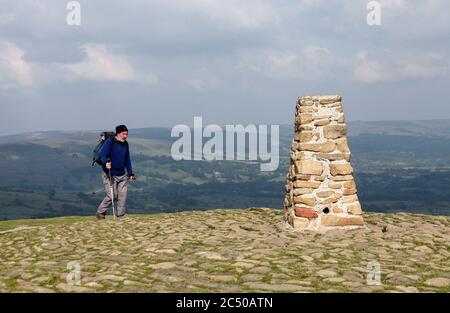 Randonneur atteignant le point de trig de pierre sur MAM Tor dans le parc national du district de Derbyshire Peak Banque D'Images