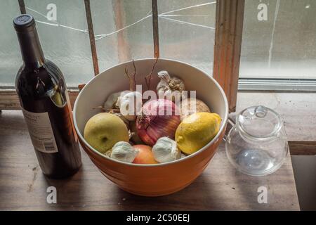 Une vie encore d'un bol de fruits et légumes mélangés assis sur un comptoir dans une cuisine. Banque D'Images