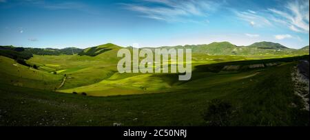 Le début de la floraison autour de Castelluccio di Norcia (juin 2020) : champs de couleur somptueuse, avec des coquelicots rouges, du colza jaune et d'autres fleurs. Banque D'Images