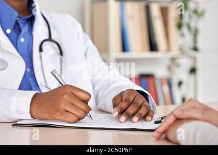 African Black médecin consulter la femme patient remplissant le formulaire médical à rendez-vous. Banque D'Images