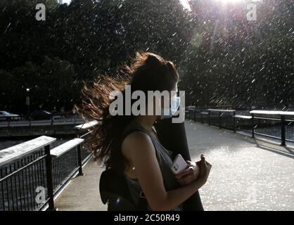 Hoboken, États-Unis. 29 juin 2020. Une femme porte un masque de protection un orage le lundi 29 juin 2020 à Hoboken, New Jersey. La ville de New York se prépare à entrer dans la phase 3 d'un plan de réouverture en quatre parties le 6 juillet après avoir été fermée pendant près de 4 mois en raison de la COVID-19. Photo de John Angelillo/UPI crédit: UPI/Alay Live News Banque D'Images