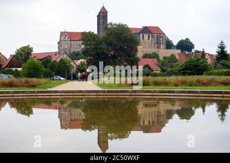 25 juin 2020, Saxe-Anhalt, Quedlinburg: La colline du château se reflète dans un bassin d'eau du jardin du monastère. Le jardin a une histoire de plus de 1000 ans. En arrière-plan, vous pouvez voir le château et l'église du château. La façon dont le jardin peut être vu aujourd'hui a été planifiée par les architectes berlinois Paul von Zelevski et Gustav Volhammer. Après la dissolution du monastère, le jardin fut vendu et mis à l'usage commercial. Le jardin du monastère de Quedlinburg fait partie du réseau "Garden Dreams - Historical Parks in Saxe-Anhalt", qui voulait célébrer son 20e anniversaire de mariage cet y Banque D'Images