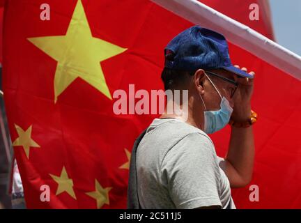 Hong Kong, Chine. 30 juin 2020. Les partisans pro-Beijing se tiennent à côté des drapeaux nationaux de la Chine et chantent l'hymne national lors d'un rassemblement pour célébrer l'adoption d'une loi sur la sécurité nationale le 30 juin 2020 à Hong Kong, en Chine. Beijing a adopté la loi controversée sur la sécurité nationale qui menacera les villes autonomie et libertés politiques crédit: May James/ZUMA Wire/Alamy Live News Banque D'Images