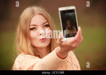 Photographie les gens concept. Jeune fille blonde en tenant un. selfies Belle femme prend photo avec téléphone mobile. Banque D'Images