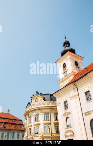 Église catholique romaine de la Sainte Trinité et hôtel de ville à Piata Mare large Square à Sibiu, Roumanie Banque D'Images