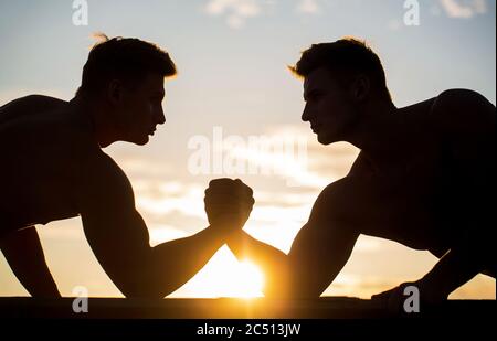 Silhouette de mains qui rivalisent en force. Rivalité, gros plan de lutte de bras mâle. Hommes mesurant les forces, les bras. Deux hommes lutte bras. Rivalité, vs Banque D'Images
