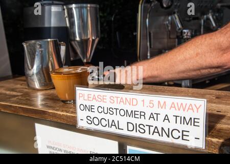 Brisbane, Australie. 30 juin 2020. Un barista sert un café près d'un panneau pour vous informer sur les distances sociales au milieu de la crise Covid-19.le Premier ministre du Queensland, Annastacia Palaszczuk, participe à une réunion du cabinet d'un État le mardi 30 juin pour annoncer une réouverture possible de la frontière et des recommandations sanitaires. (Photo de Flo Rols/Pacific Press) crédit: Agence de presse du Pacifique/Alamy Live News Banque D'Images