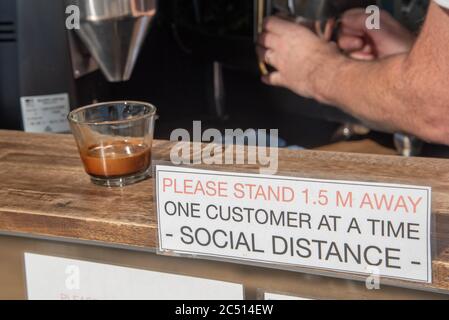 Brisbane, Australie. 30 juin 2020. Un barista sert un café près d'un panneau pour vous informer sur les distances sociales au milieu de la crise Covid-19.le Premier ministre du Queensland, Annastacia Palaszczuk, participe à une réunion du cabinet d'un État le mardi 30 juin pour annoncer une réouverture possible de la frontière et des recommandations sanitaires. (Photo de Flo Rols/Pacific Press) crédit: Agence de presse du Pacifique/Alamy Live News Banque D'Images