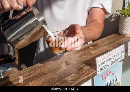 Brisbane, Australie. 30 juin 2020. Un barista sert un café près d'un panneau pour vous informer sur les distances sociales au milieu de la crise Covid-19.le Premier ministre du Queensland, Annastacia Palaszczuk, participe à une réunion du cabinet d'un État le mardi 30 juin pour annoncer une réouverture possible de la frontière et des recommandations sanitaires. (Photo de Flo Rols/Pacific Press) crédit: Agence de presse du Pacifique/Alamy Live News Banque D'Images