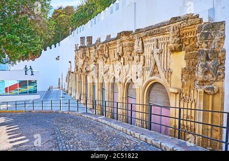 Le grand mur du palais de la Médina de Duke Sidonia avec ligne des étals du marché de Las Covachas, décoré avec des façades gothiques, Sanlucar, Espagne Banque D'Images