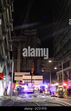 Les pompiers ont garé sur Shelley Street, près du chantier de construction de Barangaroo, le soir de l'incendie, qui peut être vu au loin. Banque D'Images