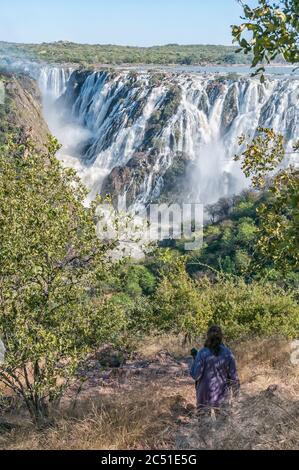 RUACANA, NAMIBIE - 21 MAI 2011 : la cascade de Ruacana dans la rivière Kunene. L'Angola est visible derrière les chutes. Un touriste est visible Banque D'Images