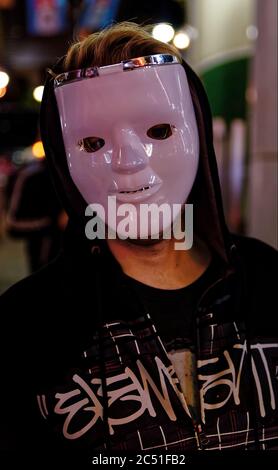 Un révélateur dans un masque blanc et un noir à capuchon sur une rue à Shibuya, Tokyo, pour célébrer Halloween Banque D'Images