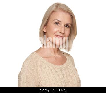 Gros plan sur une belle femme plus âgée souriant. Isolé sur blanc Banque D'Images