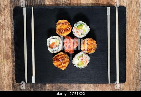 Rouleau de sushi sur l'assiette noire. Cuisine japonaise. Banque D'Images