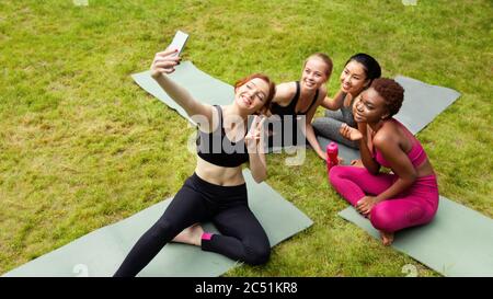 Heureux diverses filles prenant le selfie après la classe de yoga à l'extérieur, l'espace de copie Banque D'Images