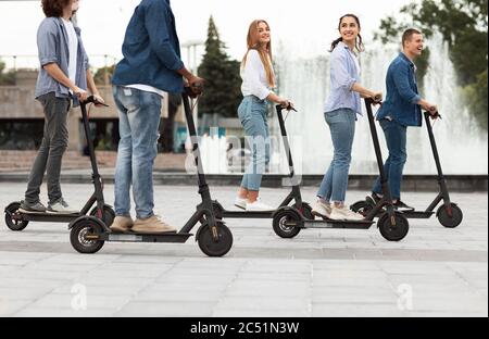 Amis qui ont une agréable promenade sur des scooters motorisés Banque D'Images