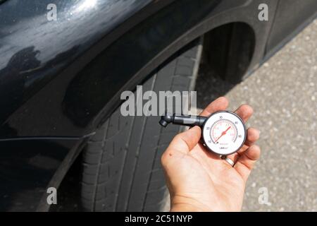 Photo du tout nouveau pneu de la voiture noire sur la route, un jour d'été Banque D'Images