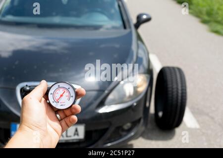 Photo du tout nouveau pneu de la voiture noire sur la route, un jour d'été Banque D'Images