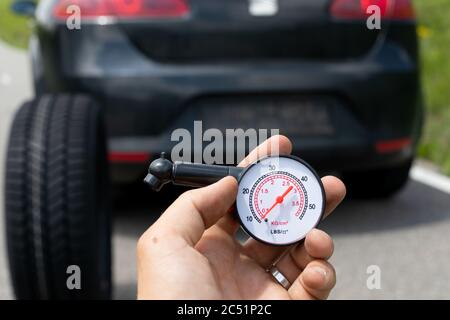 Photo du tout nouveau pneu de la voiture noire sur la route, un jour d'été Banque D'Images