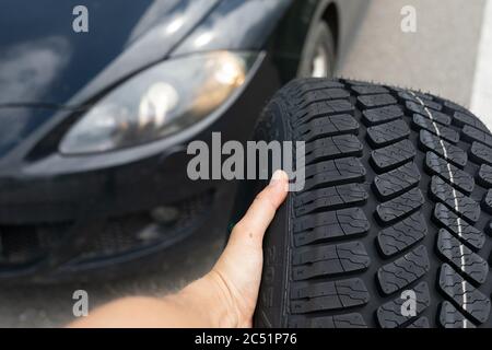 Photo du tout nouveau pneu de la voiture noire sur la route, un jour d'été Banque D'Images