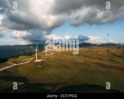 Photo aérienne d'un drone - une série d'énormes éoliennes hautes le long d'une route sur une colline parmi les montagnes au Monténégro. Banque D'Images