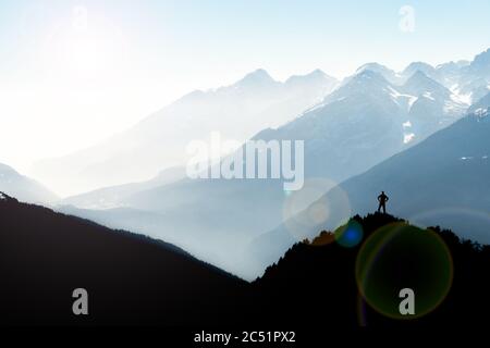 Des silhouettes spectaculaires dans les chaînes de montagnes. Homme atteignant le sommet en profitant de la liberté. Vue depuis le sommet du mont Corno di Tres, Tresner Horn. Trentin, Sud Banque D'Images