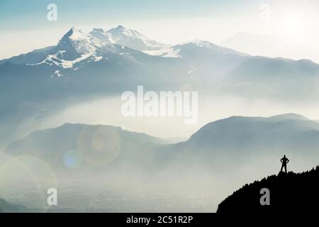 Des silhouettes spectaculaires dans les chaînes de montagnes. Homme atteignant le sommet en profitant de la liberté. Vue depuis le sommet du mont Corno di Tres, la corne de Tresner jusqu'à Cima Paganella Banque D'Images