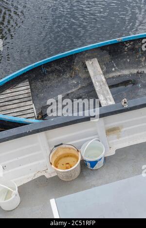 Petit et grand bateau amarré sur la rivière Fowey à Lostwhiel. Propriétaire inconnu. Travaux en cours sur le pont du plus grand bateau. Métaphore rester à flot. Banque D'Images