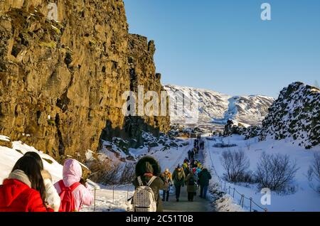 Touristes dans la crête du milieu-Atlantique plaque frontière de faille gorge avec les touristes en hiver, cercle d'or, Islande Banque D'Images