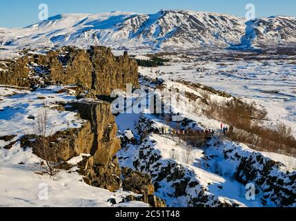 Touristes dans la crête du milieu-Atlantique plaque frontière de faille gorge avec les touristes en hiver, cercle d'or, Islande Banque D'Images