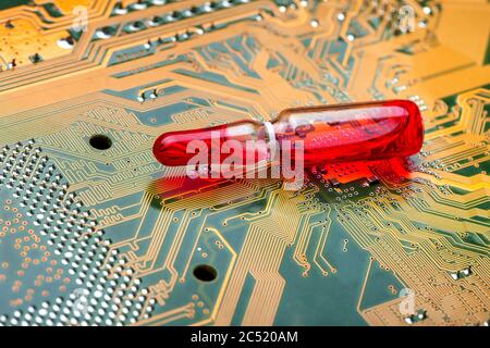 Ampoule transparente en verre avec liquide rouge médecine moderne utilisant des méthodes électroniques et des cartes de circuits imprimés en silicone cyber-imprimé, gros plan. Banque D'Images
