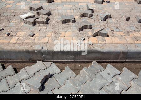 travaux de réparation sur la restauration du trottoir piétonnier pavant les carreaux de pierre et l'installation de bordures, un gros plan de la route ne travaille personne. Banque D'Images