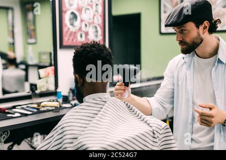 Coiffeur de salon de coiffure de la poudre sur le cou des clients avec une brosse de rasage professionnelle avant de couper les cheveux avec le rasoir. Banque D'Images