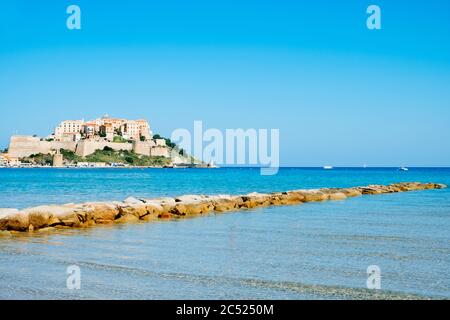 Vue sur Calvi, en Corse, en France, avec sa célèbre citadelle sur la rigole au sommet d'un promontoire, et la mer Méditerranée au premier plan Banque D'Images